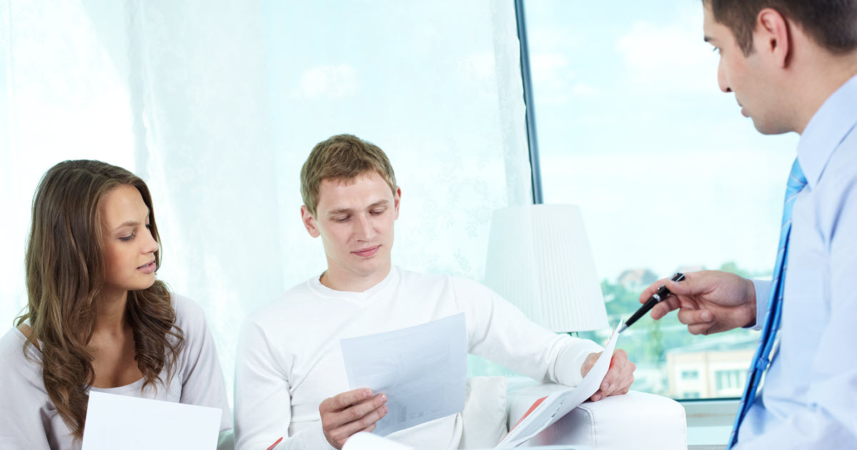 Man and woman speaking to new insurance broker in office.