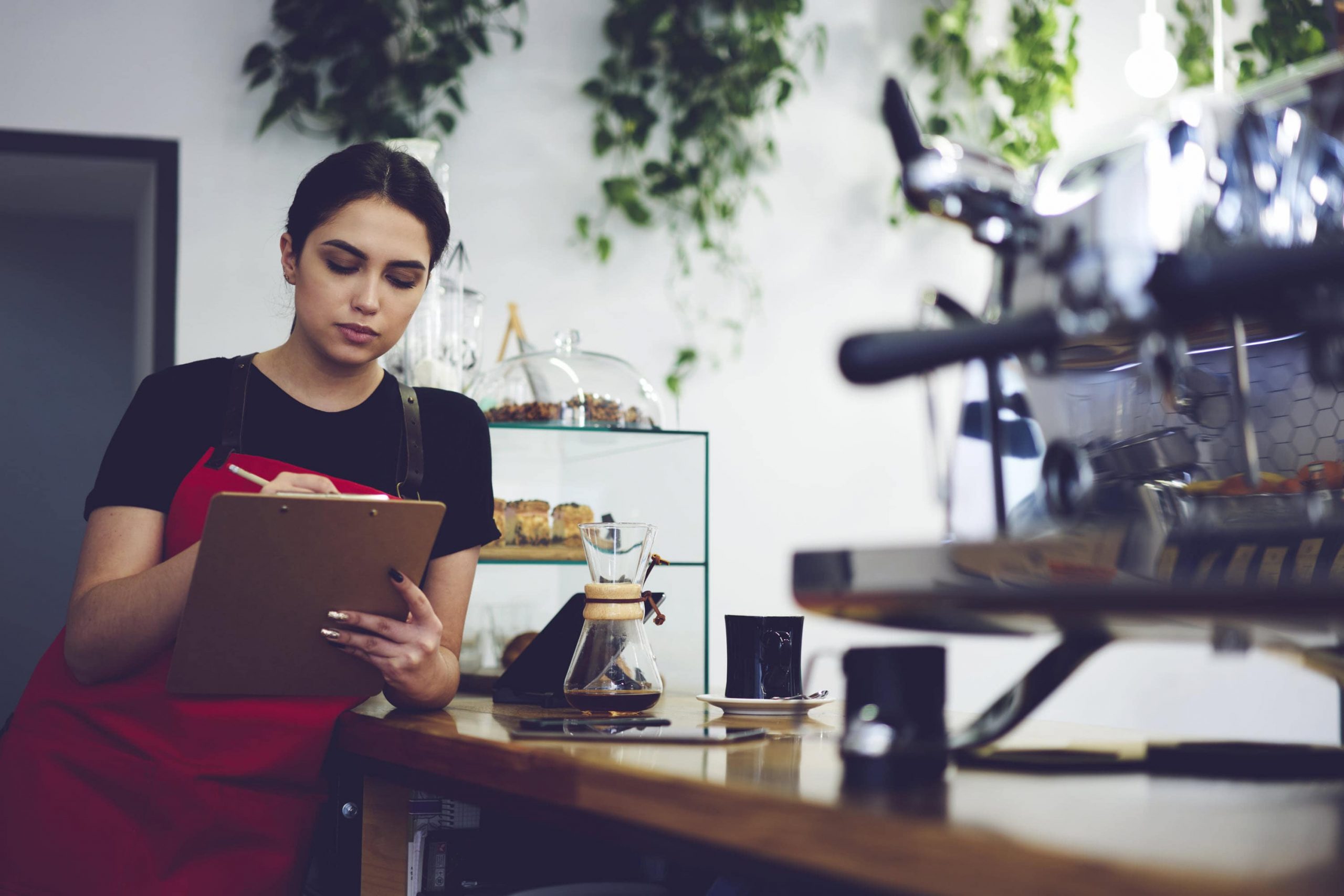 Woman working at cafe signing franchise insurance document.